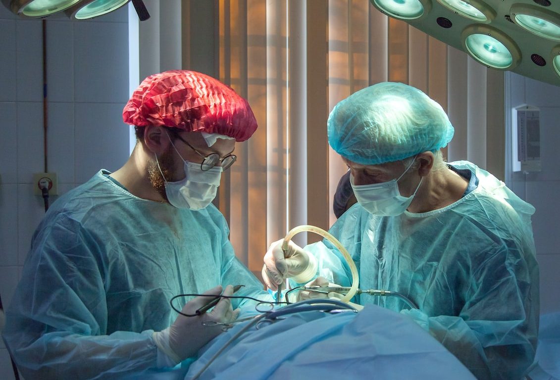 two men wearing blue lab coats